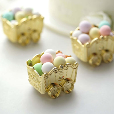 Gold decorative carts filled with pastel candy balls on a white background.