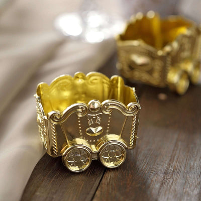 Gold decorative cart with wheels on wooden surface.