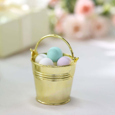 Gold miniature bucket filled with pastel-colored decorative balls.
