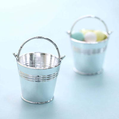 Silver metal buckets with pastel-colored eggs inside.