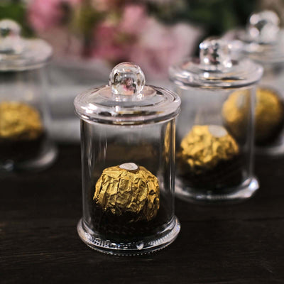 Chocolate truffles in glass display cloches on a dark surface