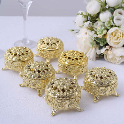 Gold decorative trinket boxes with intricate designs and floral patterns.