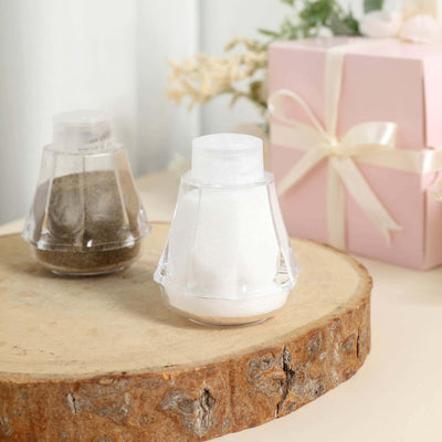 Salt and pepper shakers on a wooden surface with a gift box in the background.