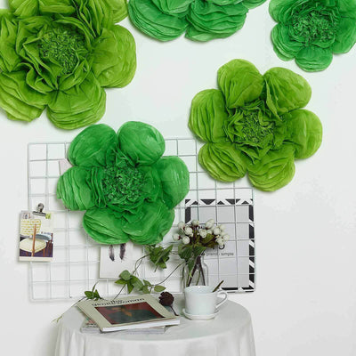 Colorful green paper flowers displayed on a grid with decor items and a cup.