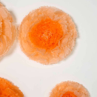 Peach tissue paper flowers in varying sizes on a white background