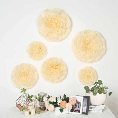 Set of five decorative cream paper flowers on a wall with various decor items below.