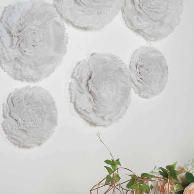 White paper flower wall decor in varying sizes for home decoration.