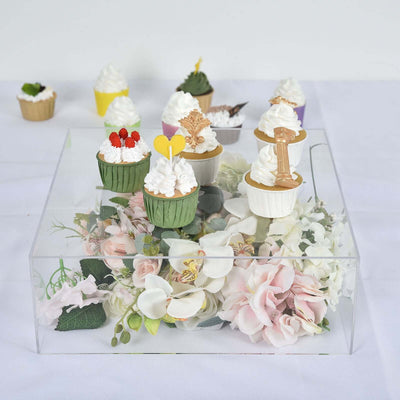 Cupcake display with floral arrangement in a clear box.