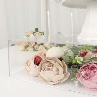 Acrylic display case with artificial flowers and greenery.