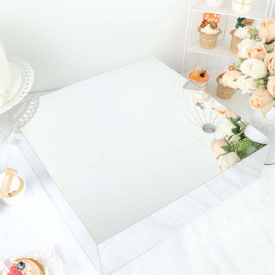 Square mirrored display stand with floral accents.