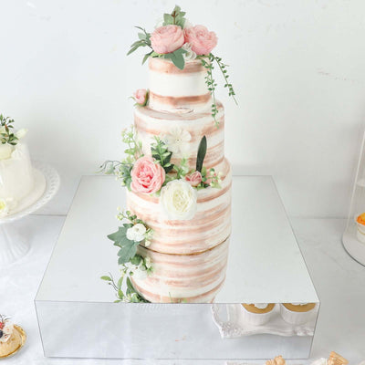 Three-tiered wedding cake adorned with pink and white flowers.