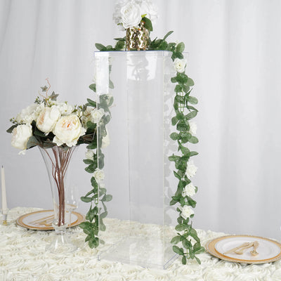 Clear acrylic display stand with floral decor on a table setting.