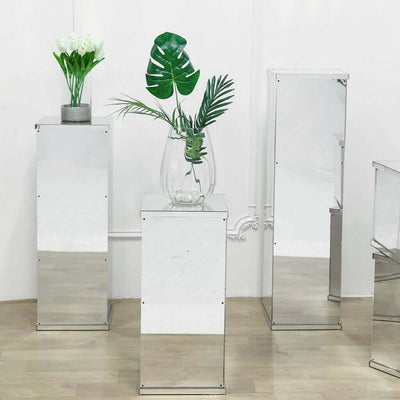 Mirrored display pedestals with plants in a bright studio setting.