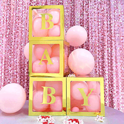 Gold and pink baby block decor with balloons for a celebration.