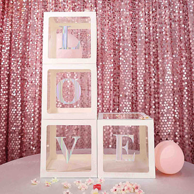 Decorative love blocks on a pink sequin backdrop.