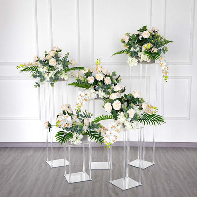 Elegant floral arrangements in clear stands for events and decor.