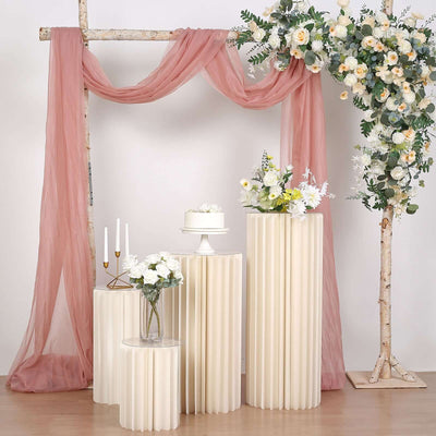 Elegant wedding decor with floral arrangements and draped fabric accents.