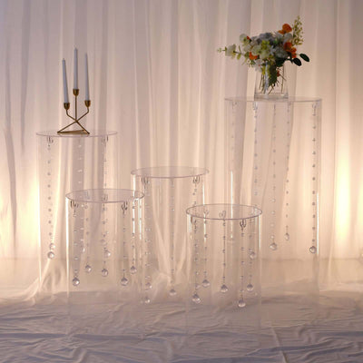 Clear acrylic display tables with hanging beads and floral arrangement.