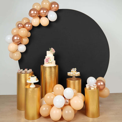 Elegant dessert table display with balloons and gold pedestals for a celebration.