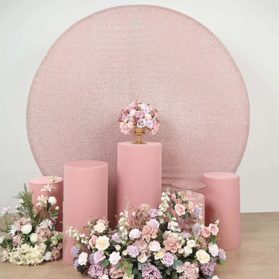 Floral arrangement on pink pedestals with a glittery backdrop.