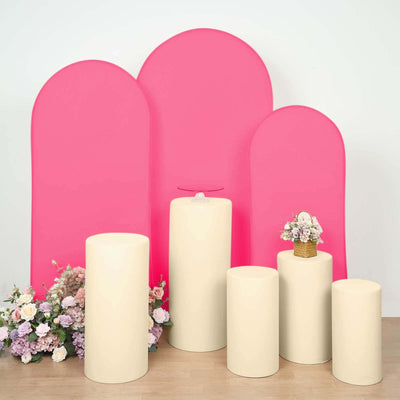 Display of cream pedestals with pink backdrops and floral arrangements