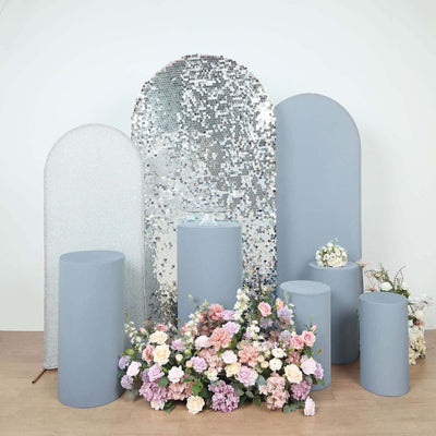 Decorative display with gray pedestals and floral arrangements.