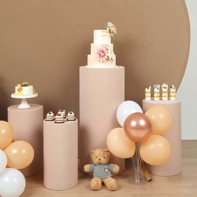 Decorative cake display with teddy bear and balloons in a staged setting.