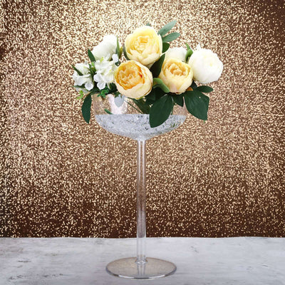 Elegant floral arrangement in a clear vase with a gold glitter backdrop.