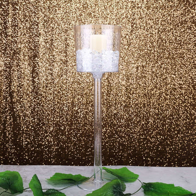 Elegant glass candle holder with decorative ice crystals and greenery.
