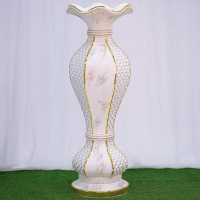 Elegant white decorative vase with gold accents on a plain background.