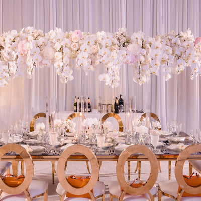 Elegant dining setup with floral centerpiece and gold-accented chairs.