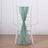 Green chiffon chair sash tied on a white chair in a minimalist setting.