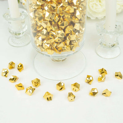 Gold decorative confetti pieces scattered around a glass jar filled with more confetti.