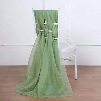 Green sheer fabric draped over a white chair in a minimalist setting.