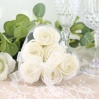 White rose soap flowers in a heart-shaped box with a ribbon.