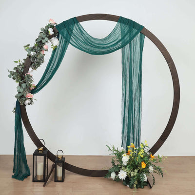 Decorative wedding arch with floral accents and lanterns on a plain background.