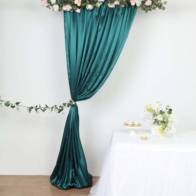 Teal satin drapery with floral accents and a table setting.