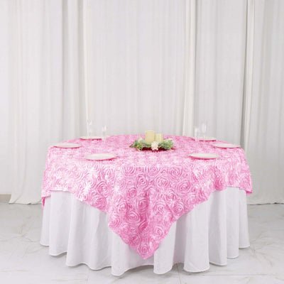 Pink rose-patterned tablecloth draped over a round table with elegant decor.