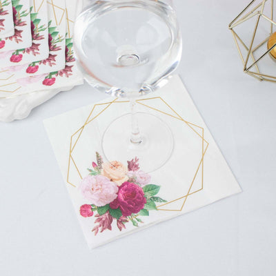 Floral-patterned cocktail napkin with gold geometric design.