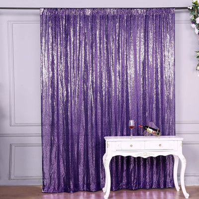 Purple sequin backdrop curtain hanging behind a white table with a drink.