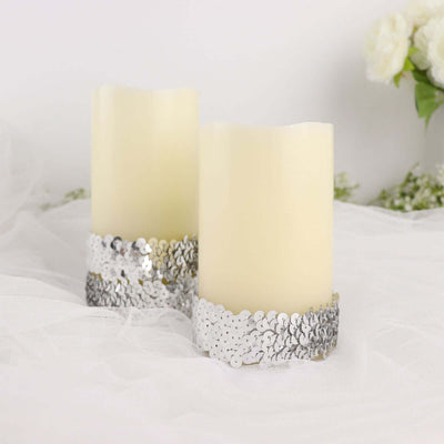 Decorative flameless candles with silver sequined bases on a soft white background.