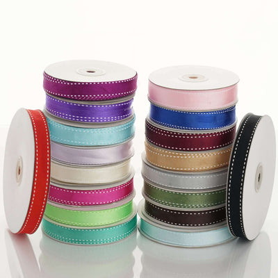 Assorted ribbon spools in various colors and widths stacked together.