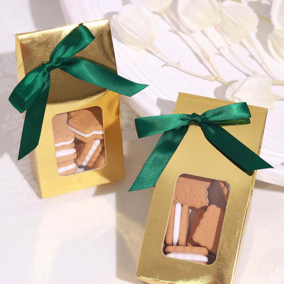 Gold gift boxes with cookies, adorned with green ribbons.