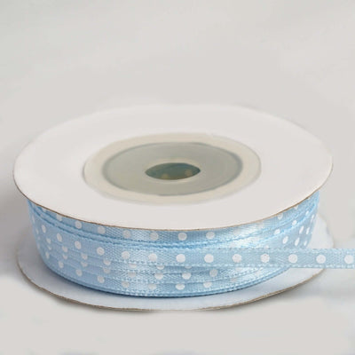 Light blue polka dot ribbon on a spool, ideal for crafts and decorations.