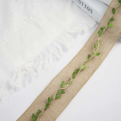 Embroidered burlap ribbon with leaf design on a white background.