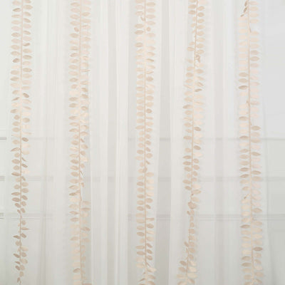 Decorative sheer curtain with leaf patterns hanging vertically