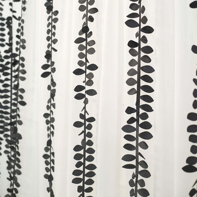 Black leaf pattern curtain panel on a light background.