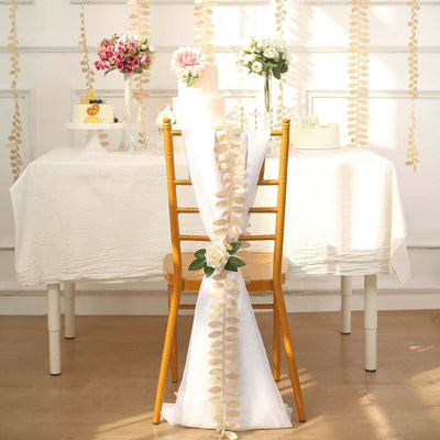 Decorated chair at a festive table with floral arrangements and a cake.
