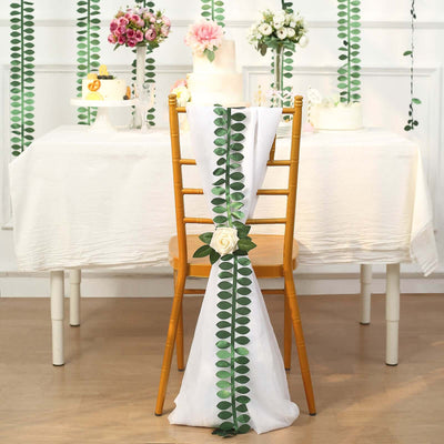 Decorative chair cover with greenery and flower for event styling.