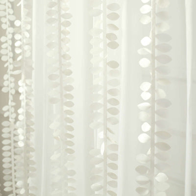 White sheer curtain with leaf pattern details.